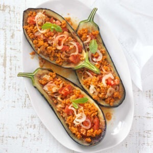 Textured Soya Protein Mince served in aubergines with tomatoes and onion.