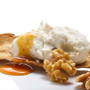 Vegan Blue Spreadable Cheese Alternative by MozzaRisella served on a cracker with walnuts.