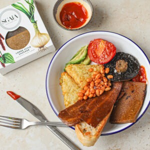 Vegan Lorne Style Sausages by Sgaia served on a vegan breakfast with hash browns, toasted bread, Sgaia Smoky Flavour Rashers, baked beans, grilled mushroom, grilled tomato, avocado and tomato sauce.