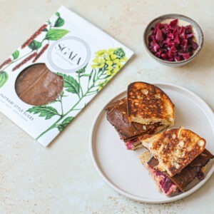 Vegan Pastrami Style Slices by Sgaia served in a sandwich with red cabbage.