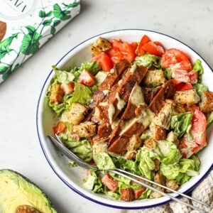 Vegan Smoky Flavour Steaks by Sgaia served as strips in a salad with lettuce, tomatoes, croutons and dressing.