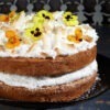 Vegan Creamy Original Cheese Alternative by Violife whipped up and spread in a vegan cake, decorated with edible flowers and coconut shavings.