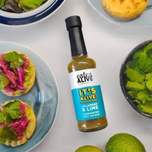 Vegan Lime and Jalapeno Fermented Hot Sauce by Eaten Alive served on crackers with Eaten Alive Smoky Pink Kraut, avocado and fresh coriander.