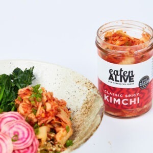Vegan Classic Spicy Kimchi by Eaten Alive served over a grain salad with radish and broccolini.