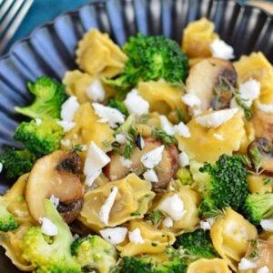 Vegan Blue Cheese Alternative Wedge by Greenvie served crumbled on top of broccoli and mushroom pasta.