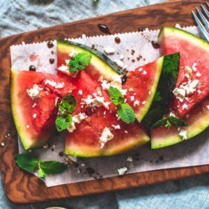 Vegan Greek Style Feta Cheese Alternative Block by Greenvie served crumbled onto fresh watermelon with mint.