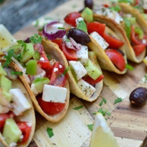 Vegan Greek Style with Olive Oil and Oregano Feta Cheese Alternative Block by Greenvie served cubed into Greek salad tacos with olives, cucumber, tomatoes and red onion.