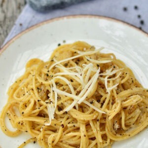 Vegan Parveggio Parmesan Cheese Alternative Wedge by Greenvie served grated onto spaghetti.