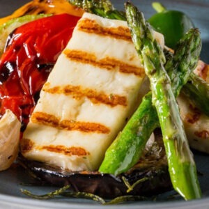 Vegan Vegrill Halloumi Cheese Alternative Block by Greenvie served grilled with grilled asparagus, aubergine and peppers.