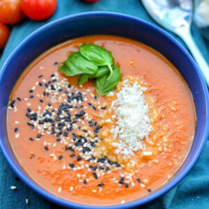Vegan Grated Parveggio Parmesan Cheese Alternative by Greenvie served in a tomato soup with fresh basil and sesame seeds.