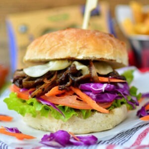 Vegan Mozzarella Cheese Alternative Slices by Greenvie served in a burger bun with onions, cabbage, tomato, carrot and salad.