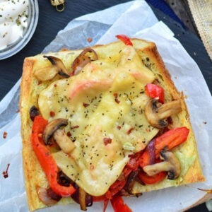 Vegan Smoked Gouda Cheese Alternative Slices by Greenvie served melted on bread with mushrooms, peppers and onions.