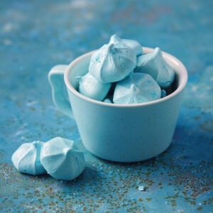 Vegan Candy Floss Meringues by London Apron shown in a blue mug on a blue background.