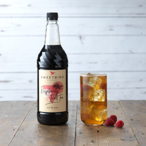 Vegan Raspberry Iced Tea Syrup by Sweetbird served in a cool iced tea drink with ice and raspberries.