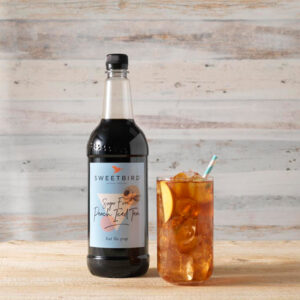 Vegan Peach Iced Tea Sugar-Free Syrup by Sweetbird served in a cool iced tea drink with ice and peach.