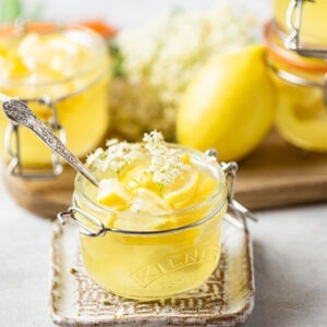 Vegan Lemon Jelly by Just Wholefoods served in jars topped with fresh lemon and elderflower.