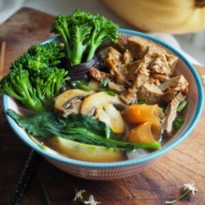 Vegan Braised Tofu by Marigold served in a vegan broth ramen bowl with broccolini, mushrooms, carrot and greens.