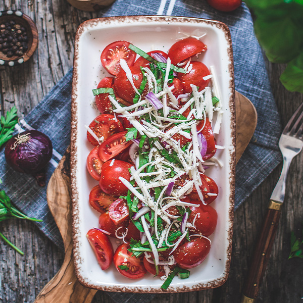 Vegan Mozzarella Cheese Alternative by GreenVie served with a tomato, onion, and herb salad.