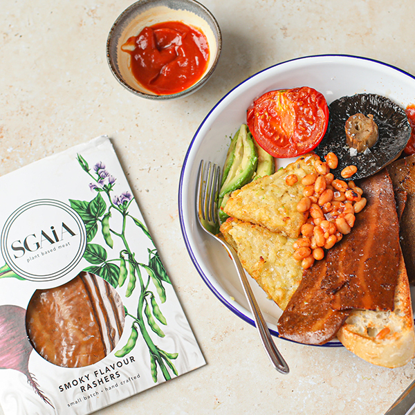 Vegan Smoky Flavour Bacon Rashers by Sgaia served with ketchup, tomato, mushroom, avocado, hash browns, beans, and bread.