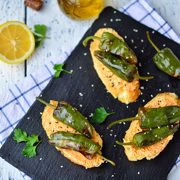 GreenVie Spread with Tomato and Basil served on crostini with grilled padron peppers.