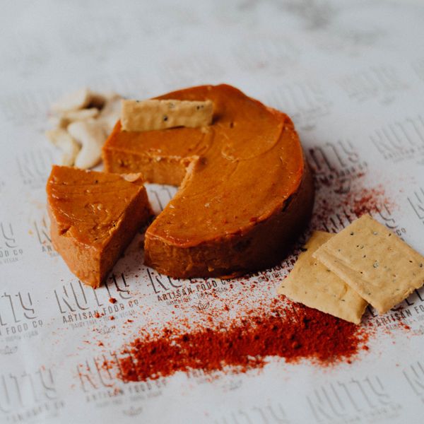 Vegan Aged with Paprika by Nutty Artisan Co shown next to some crackers, cashews and paprika.
