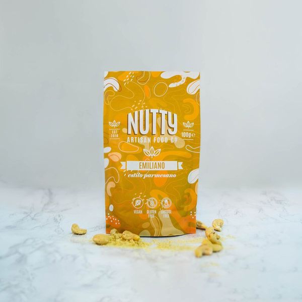 Vegan Emiliano by Nutty Artisan Co shown scattered in front of packet, next to some cashews.