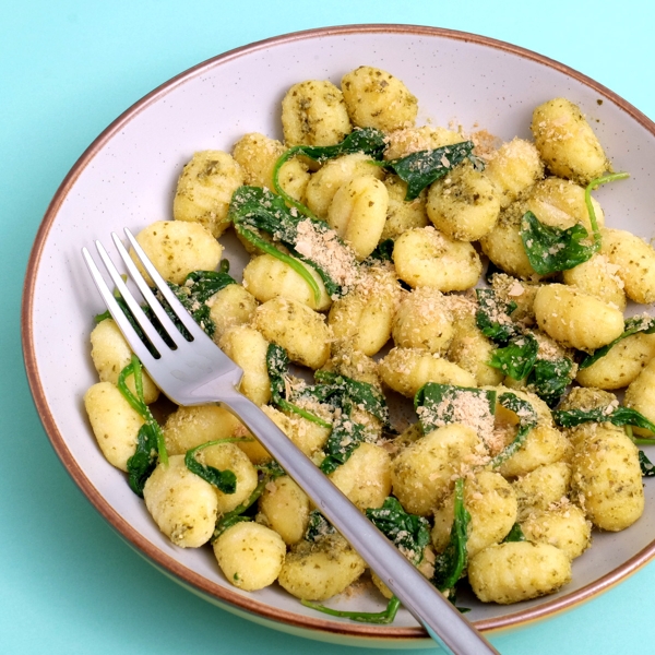 Vegan Cheesy Seasoning by Notorious Nooch Co served with gnocchi and wilted spinach.